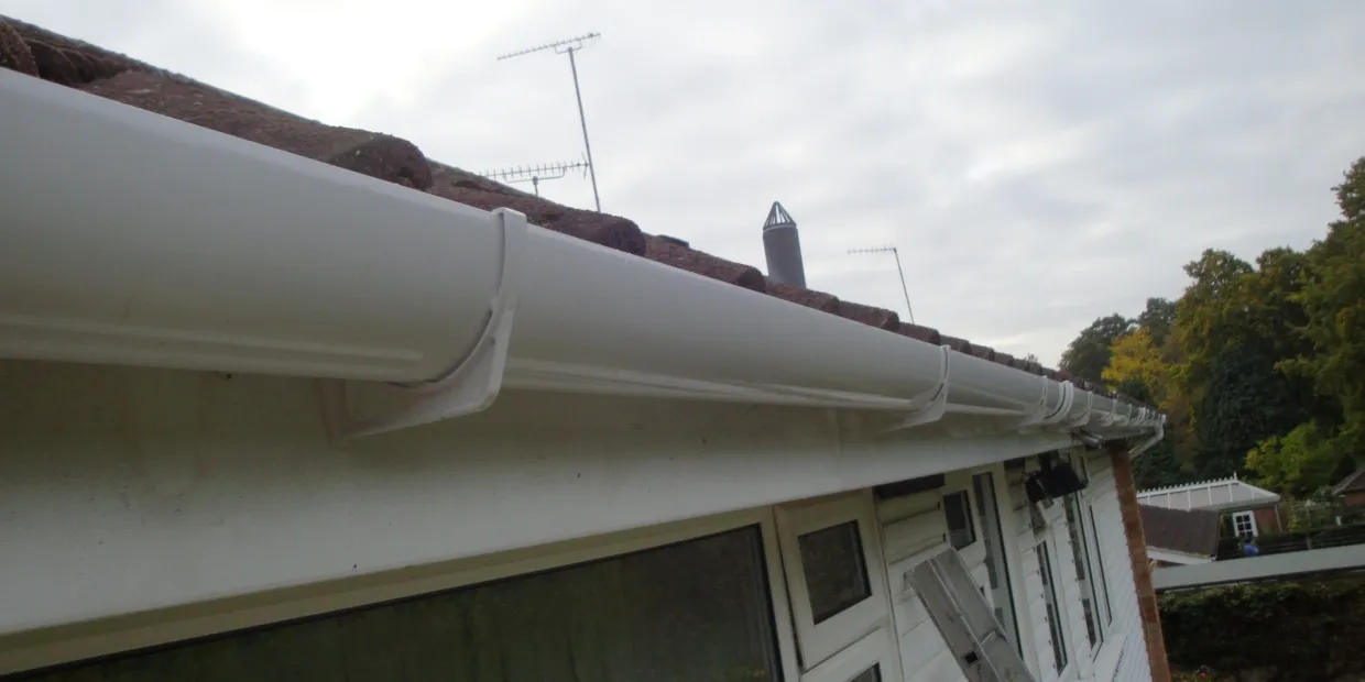 New white uPVC guttering, fascia and soffit fitted along a bungalow roof edge in Surrey